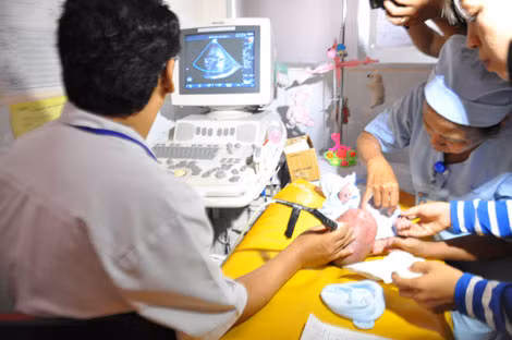 BS Nguyễn Hữu Chí thực hiện siêu âm vùng đầu cho bé.