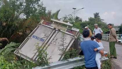 Xe tải tông lan can cầu rơi xuống kênh, tài xế mắc kẹt trong cabin