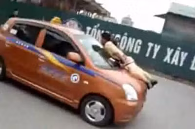 Đồng chí Long bị hất lên nắp capo xe taxi.