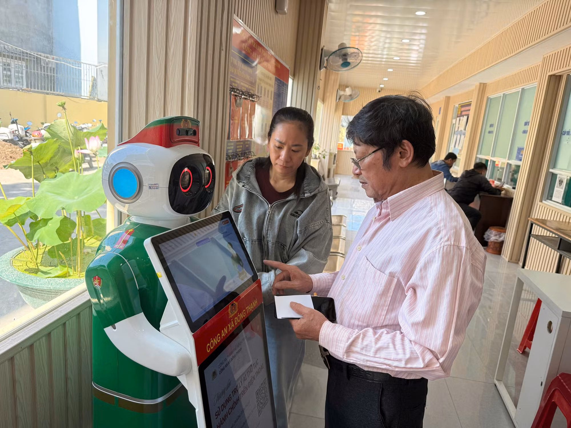 Người dân sử dụng các tiện ích từ “Robot lễ tân Công an xã”.
