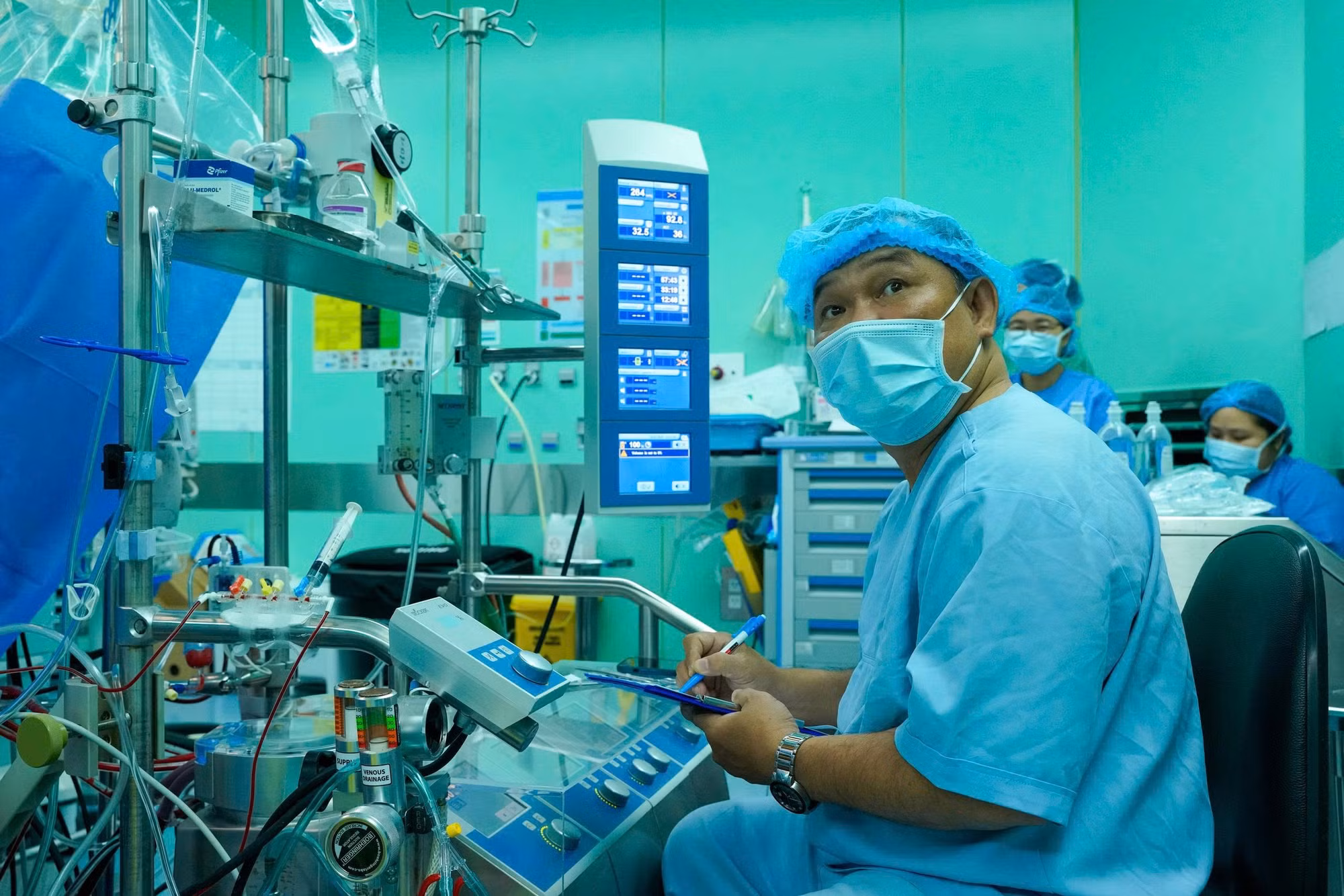 Song hành cùng các phẫu thuật viên, ê-kíp vận hành hệ thống tuần hoàn ngoài cơ thể (ECMO) kiểm soát nghiêm ngặt từng chỉ số sinh tồn của bệnh nhân suốt quá trình ghép tim.