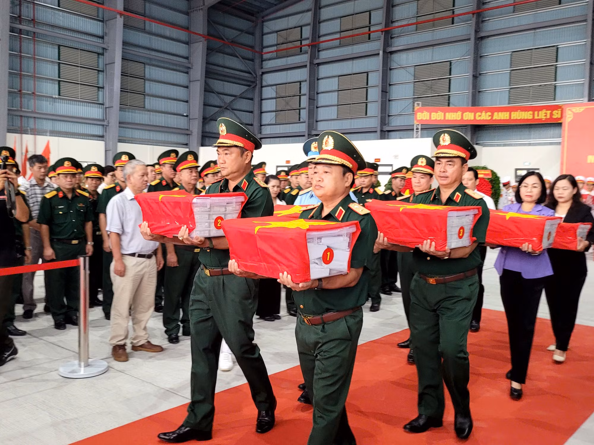 Lãnh đạo Quân khu 7 cùng các đại biểu đưa các mẫu hài cốt liệt sĩ lên máy bay vận tải quân sự.