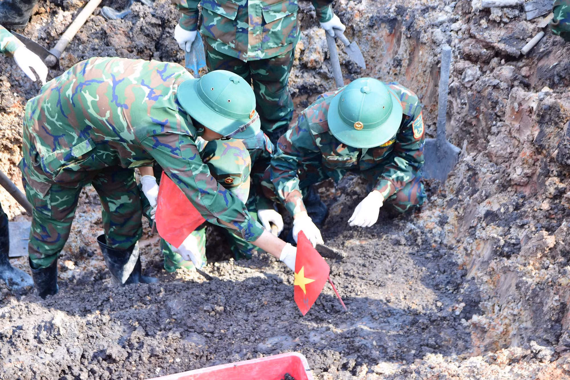 Các cán bộ chiến sĩ cẩn trọng, tỉ mỉ sới đất, tìm từng mẩu hài cốt, di vật.