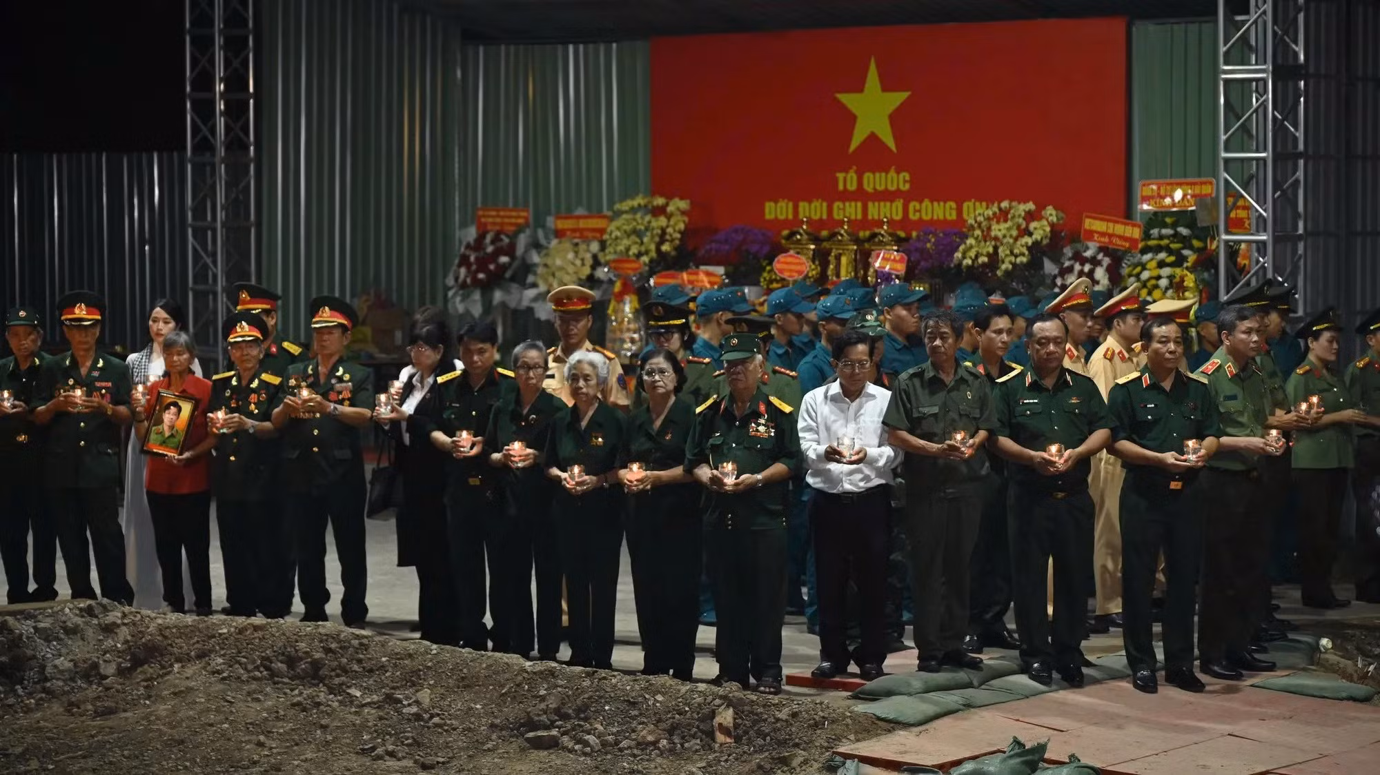 Các đại biểu thắp nến tri ân các anh hùng liệt sĩ tại khu vực khai quật hài cốt liệt sĩ ở Công viên Lê Thị Riêng.