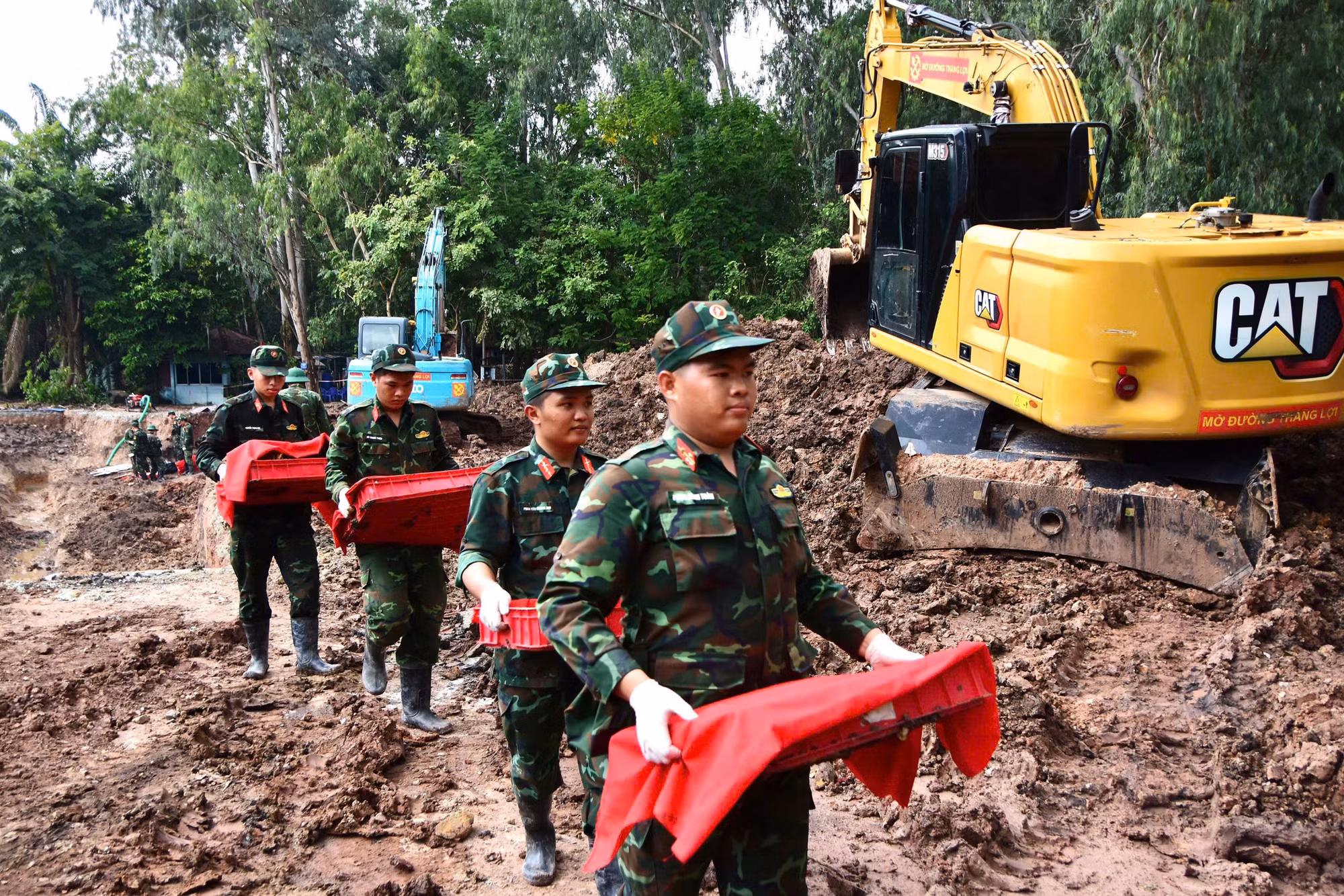 Cán bộ chiến sĩ đưa hài cốt liệt sĩ vừa mới được tìm thấy về nơi tập kết.