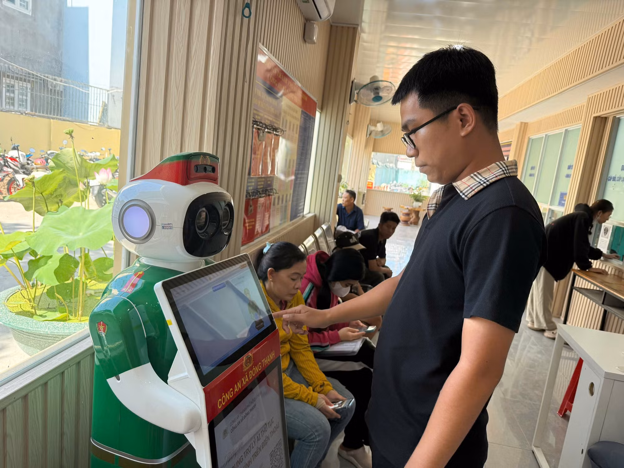 Anh Trần Văn Quân sử dụng các tiện ích từ “Robot lễ tân Công an xã”.