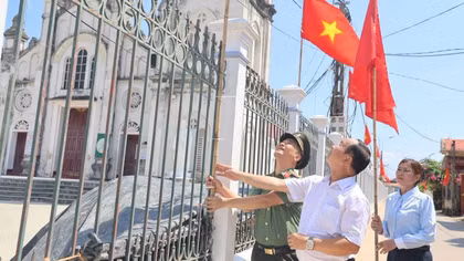 Các cán bộ Công an cùng đại diện các cơ sở tôn giáo treo Cờ Tổ quốc.
