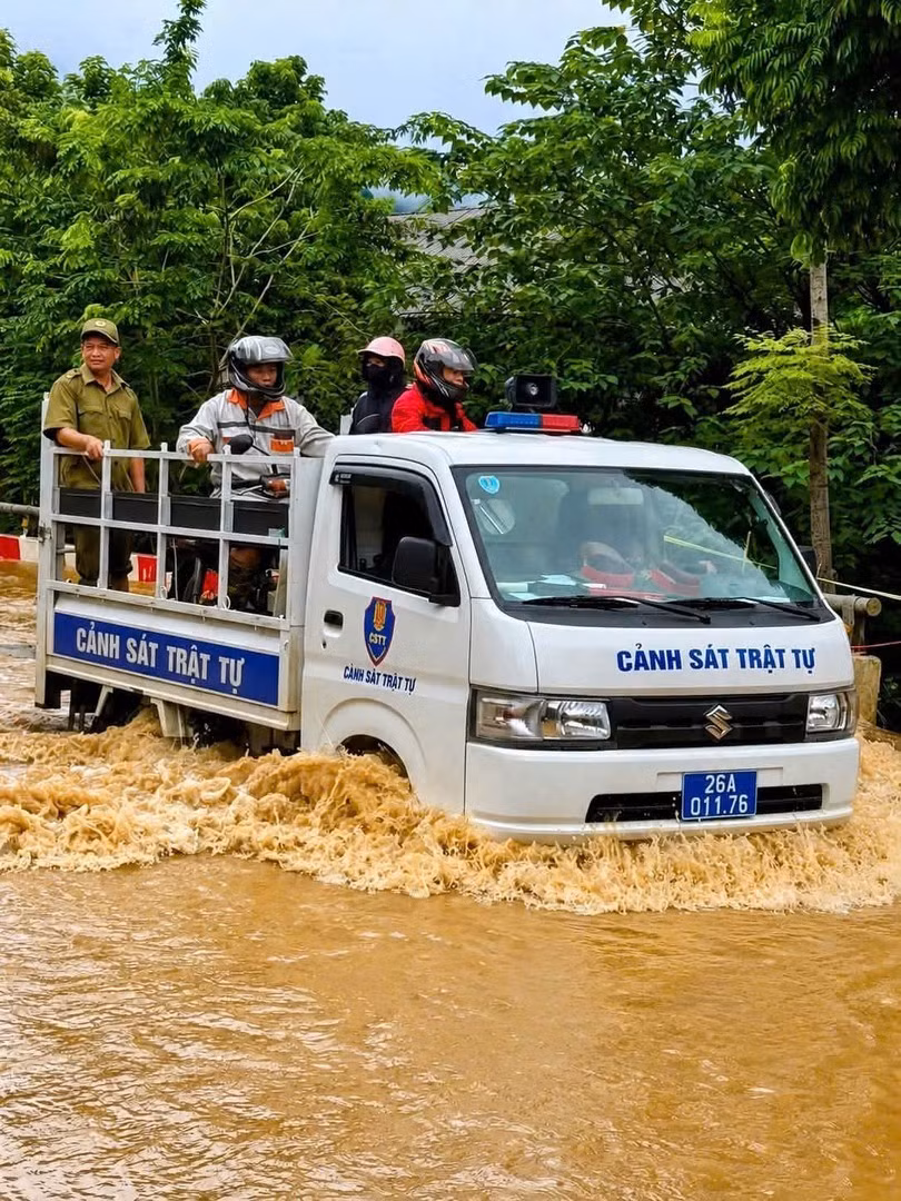 Công an xã Quỳnh Nhai hỗ trợ nhân dân di chuyển qua một số điểm ngập sâu.