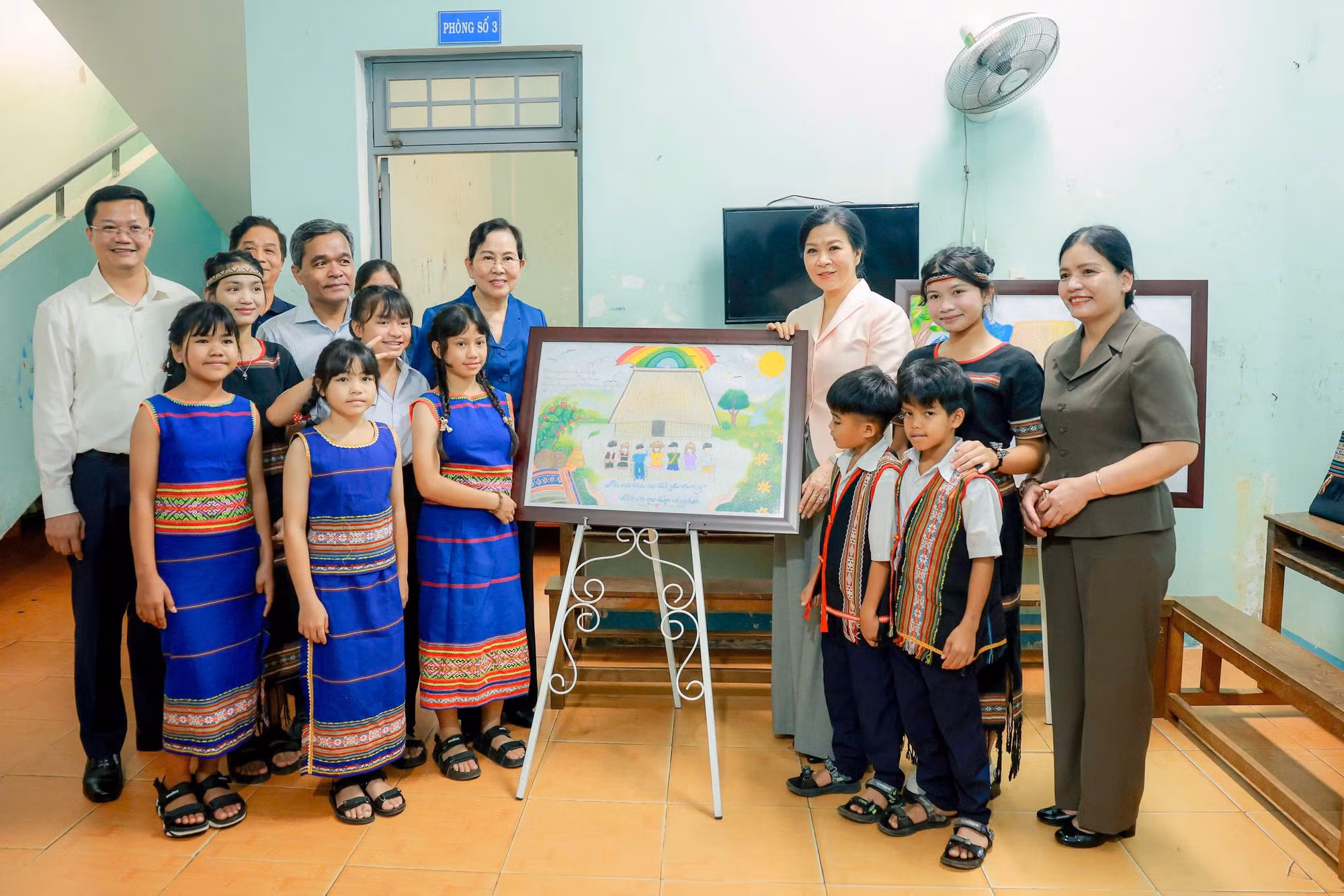 Đoàn công tác bên bức tranh của học viên trung tâm.